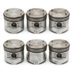 Close-up view of metal engine pistons with piston rings used in automotive engine assembly